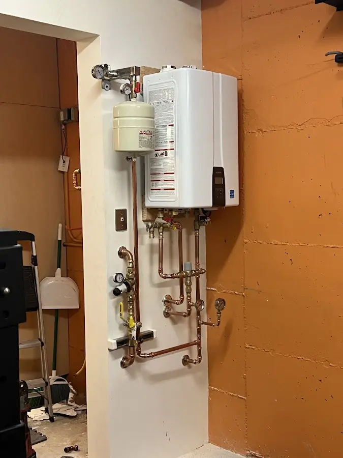 Plumbing technician inspecting water heater connections in Gretna